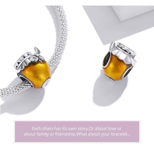 A Sterling 925 silver charm designed as a honey jar with a bee on top, filled with yellowish liquid representing honey. showed on pandora bracelet