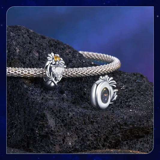 Sterling 925 Silver April Daisy Clear Birthstone Charm – Pandora Compatible on a bracelet against a textured background.