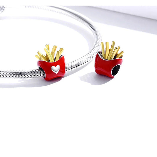 Sterling silver charm in the shape of a French fries container with a red exterior and gold-colored fries, featuring a white heart emblem on the front.