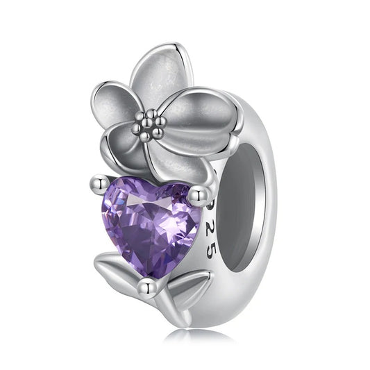 Sterling silver charm with a purple violet birthstone and a floral design, compatible with Pandora bracelets.