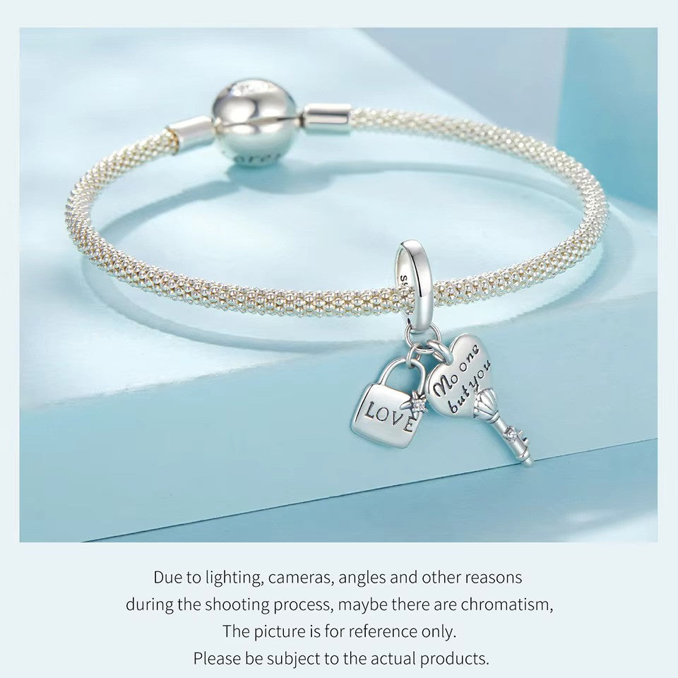 sterling 925 silver charm with a lock engraved with ( love ) and a star with a small zircon stone and a key with heart engraved with ( no one but you ) and the body of the key is shell with a small zircon stone.