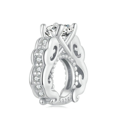 Silver ring with intricate design and clear gemstone on a white background