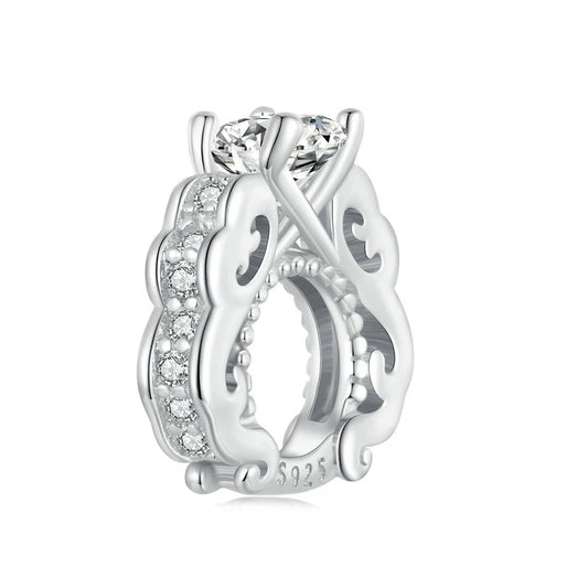 Silver ring with intricate design and clear gemstone on a white background