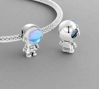 sterling 925 silver astronaut-themed charms with blue gemstones on a white background